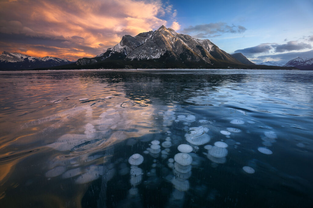 red sunset clouds over frozen lake and mountains