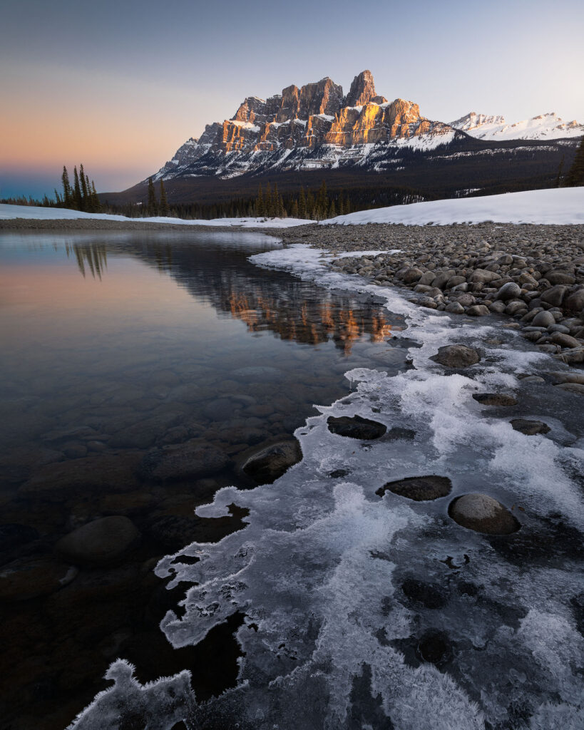 Crispy ice leads up to a sunrise-lit Castle Mountain